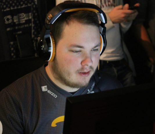A man wearing headphones is sitting in front of a computer.